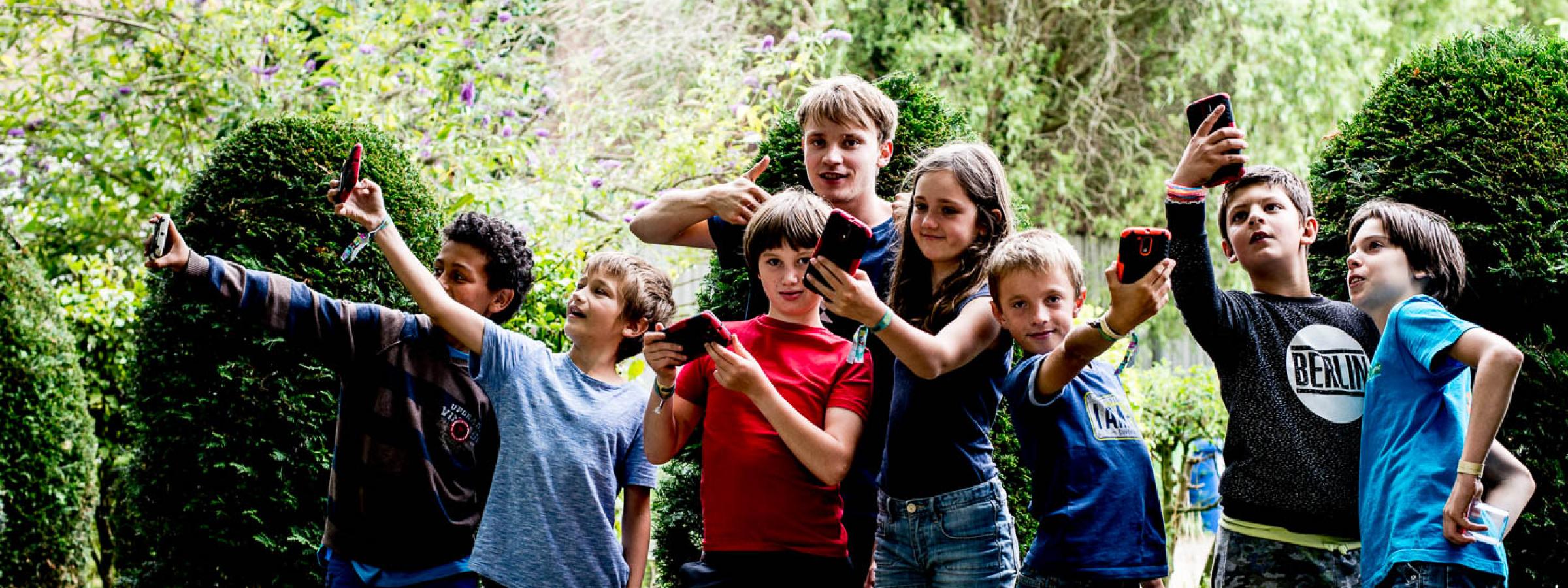 Groepje kinderen met smartphones in de lucht 