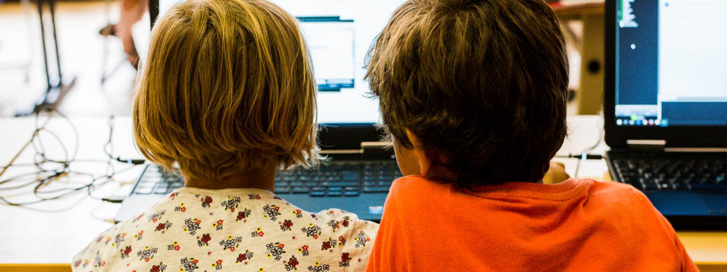 Jongen en meisje werken samen op een laptop