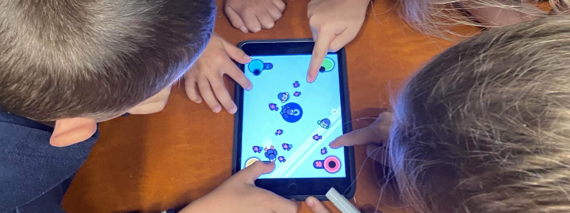 Vier kinderen spelen samen op een tablet