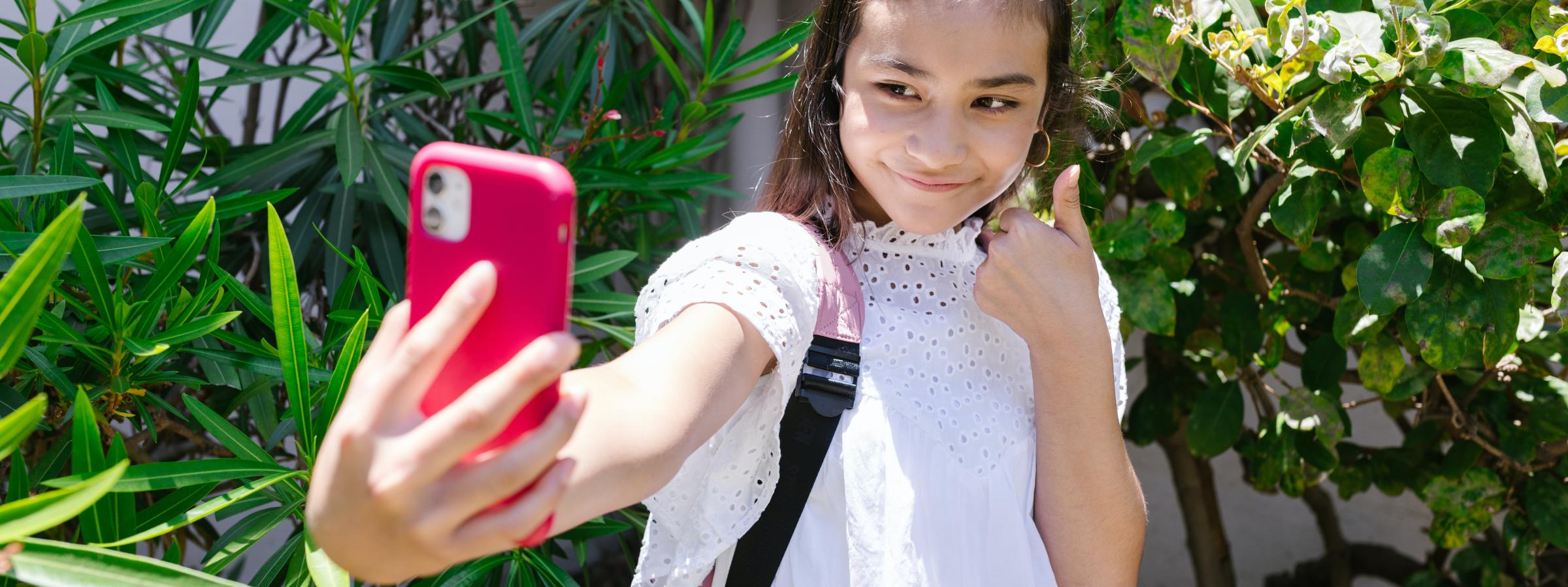 Meisje steekt duim omhoog en maakt selfie 