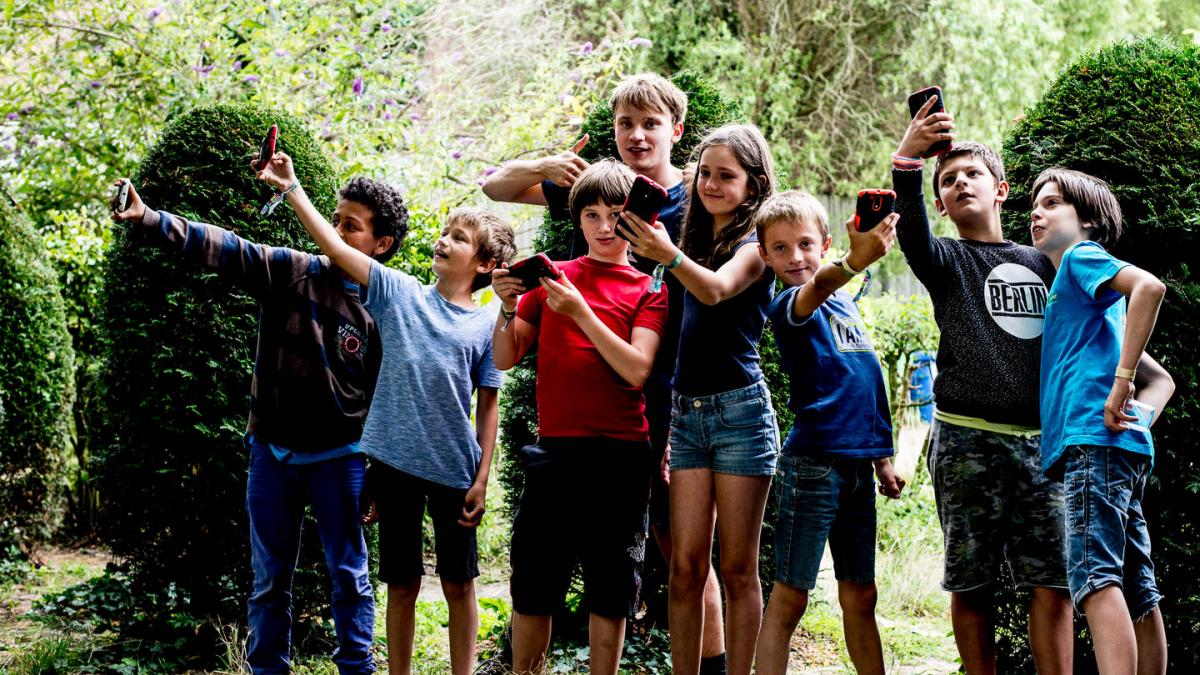 Groepje kinderen met smartphones in de lucht 