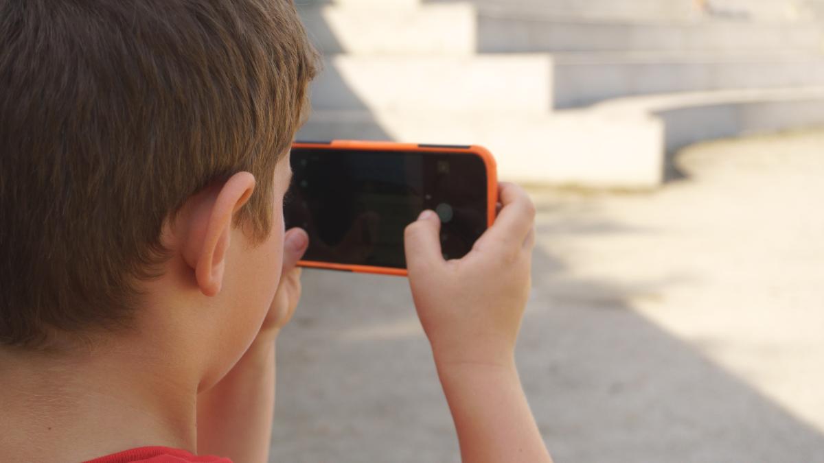 Jongen filmt horizontaal met smartphone 