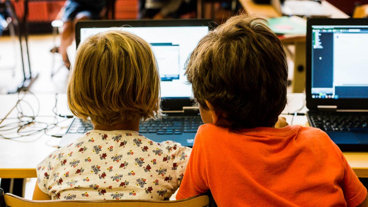 Jongen en meisje werken samen op een laptop