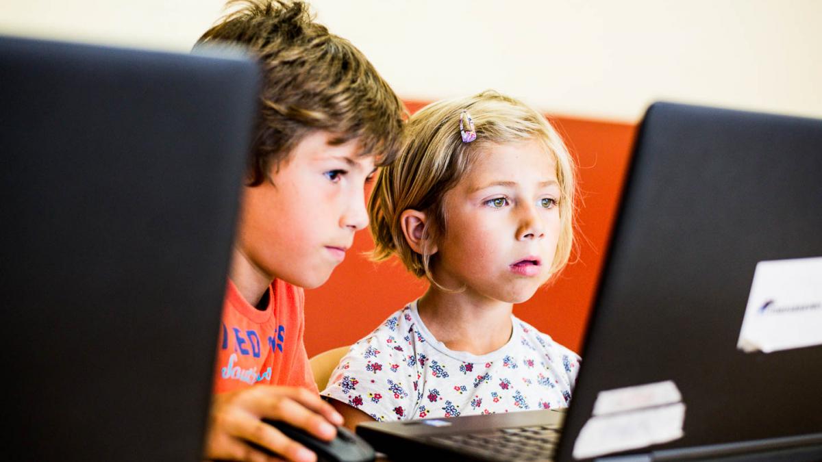 Jongen helpt meisje op laptop