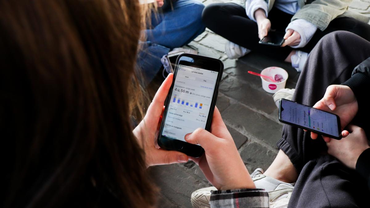 Jongeren op de grond met hun smartphone vast