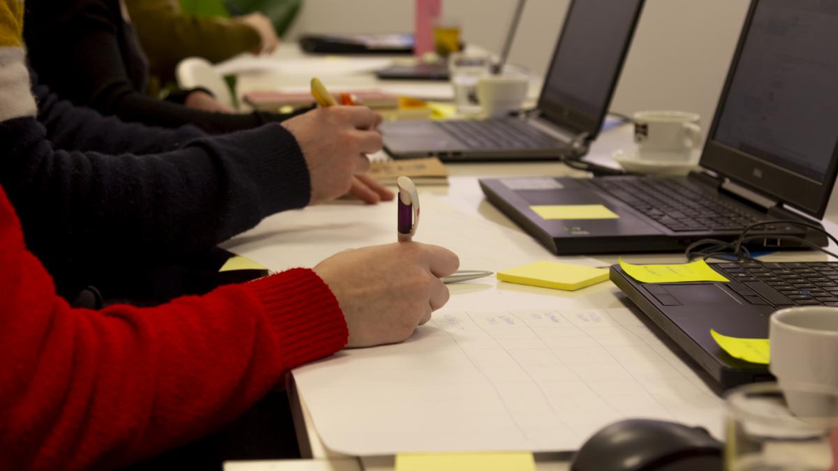 Laptops en schrijvende handen