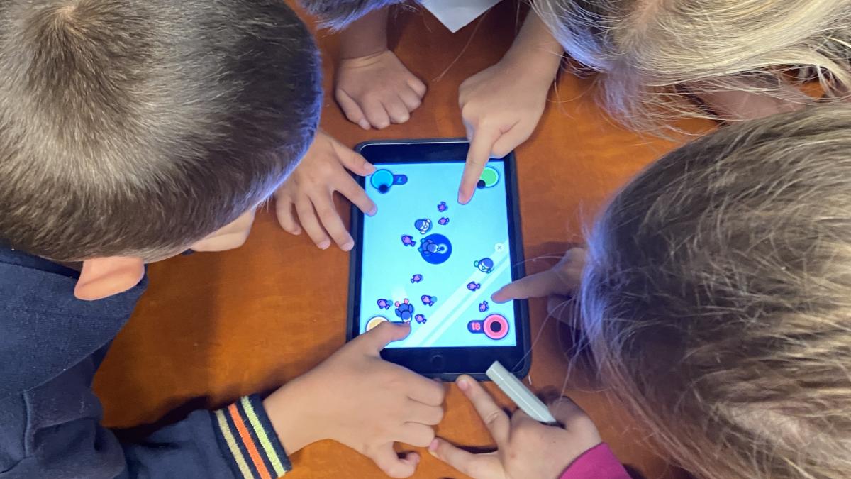Vier kinderen spelen samen op een tablet